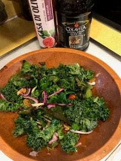 A wooden bowl of salad on top of a table.