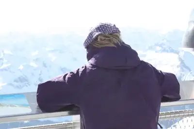 A person standing on top of a building looking at the sky.