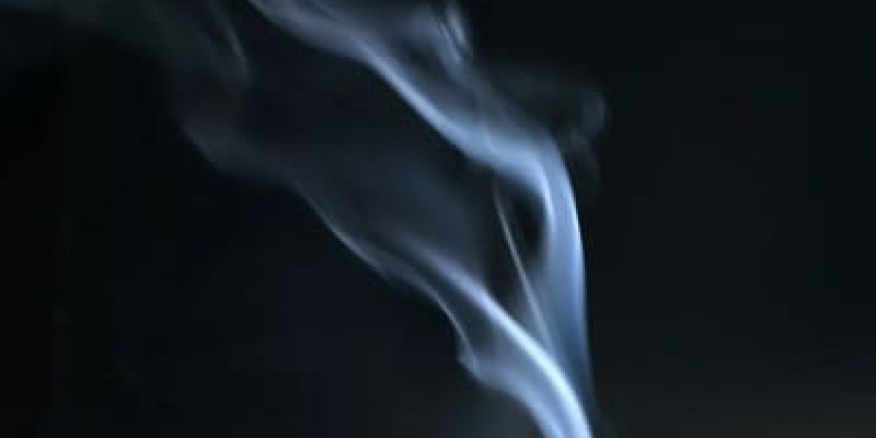 A cigarette is lit up by the smoke.