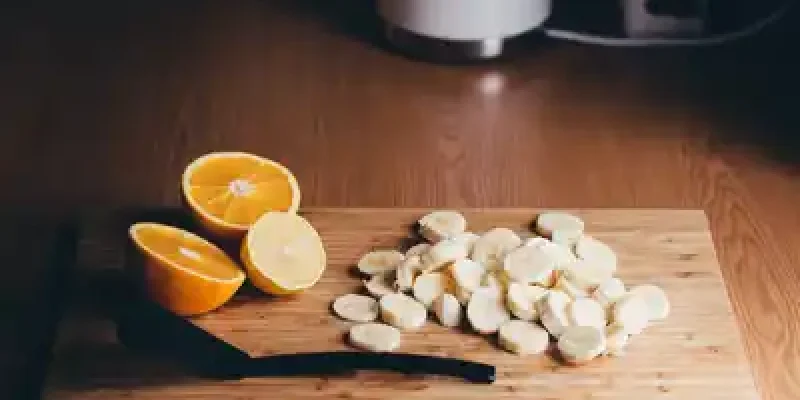 A cutting board with sliced bananas and oranges on it.