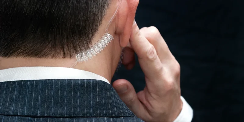 A man in a suit is talking on his phone.