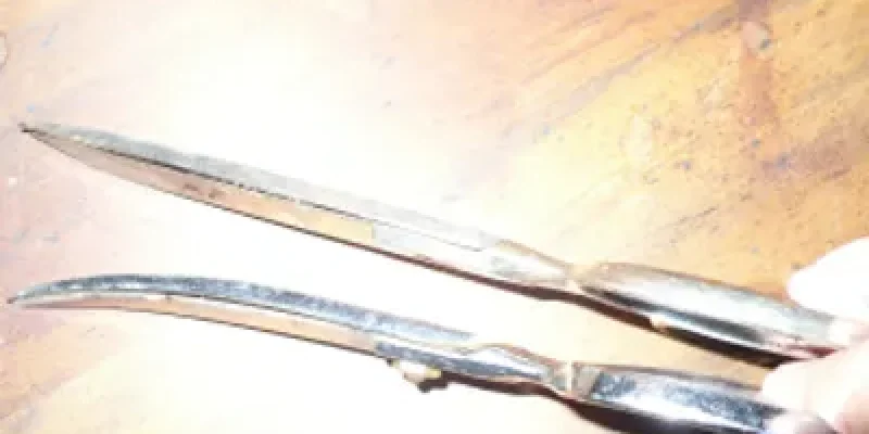 A pair of scissors sitting on top of a wooden table.